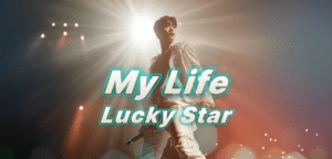 A performer stands on stage under bright lights, holding a microphone, with the text My Life Lucky Star in bold, teal letters across the image.